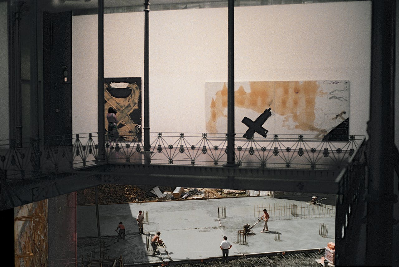 A juxtaposition of modern art and construction ongoing in a gallery setting.